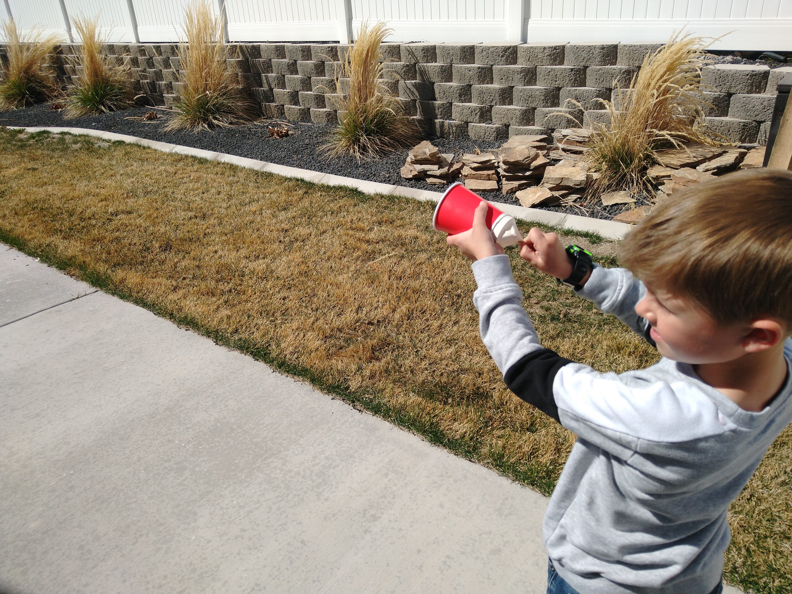 Boy using the marshmallow shooter by pulling back on the balloon